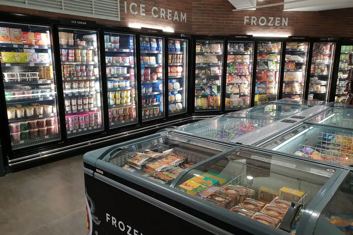 Commercial refrigeration repair in Layton Utah showing grocery store ice cream and frozen food coolers with glass doors and chest freezers fully stocked and operating properly.<br />