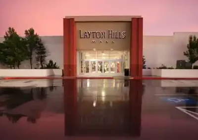 Front entrance of Layton Hills Mall in Layton Utah at sunset with reflections on wet pavement