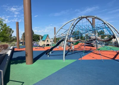Family-friendly playground equipment at South Ogden Nature Park with children playing and shaded seating nearby